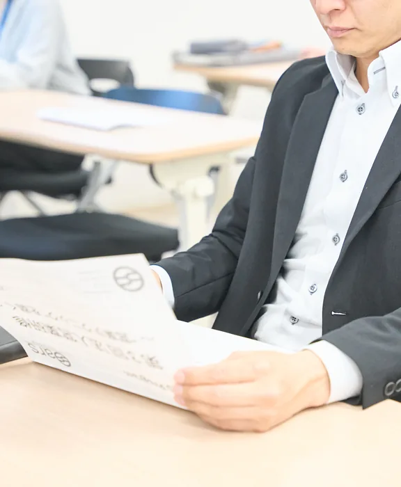 手にした資料に目を通している男性。